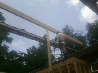 Carpenter setting a ridge beam over a new addition frame — Ice Dam Removal by Roofing Brothers in Louviers