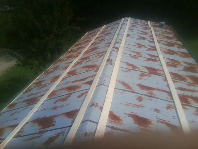 Rusted metal roof panels with new wood purlins before replacement — Storm Damage Roof Repair in Louviers by Roofing Brothers